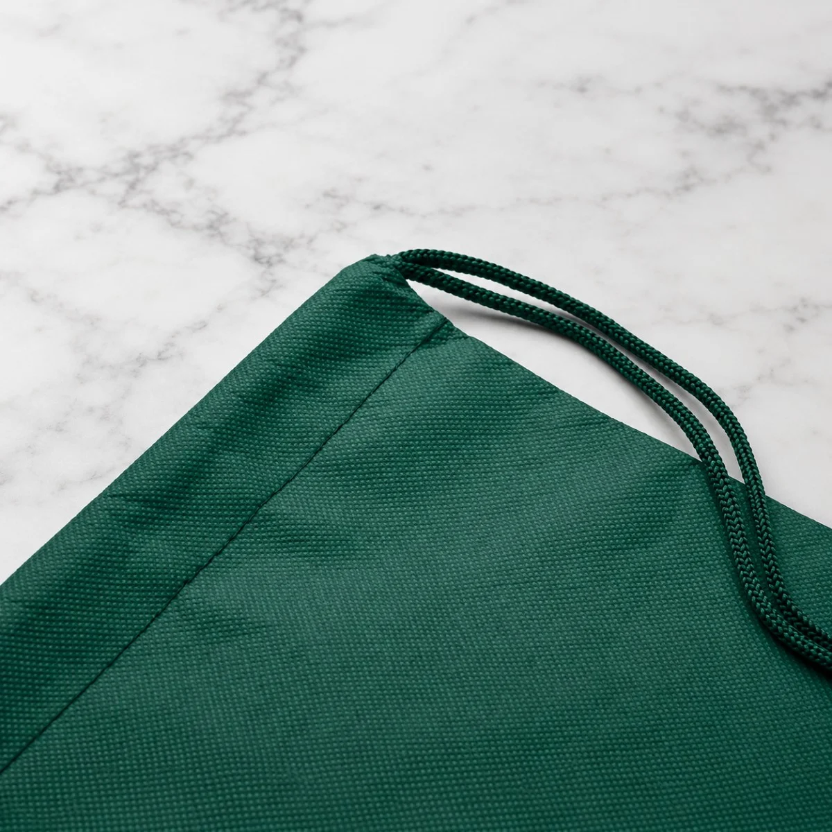 Close-Up Of Dark Green Non-Woven Fabric With Green Stitching And Cord Handle